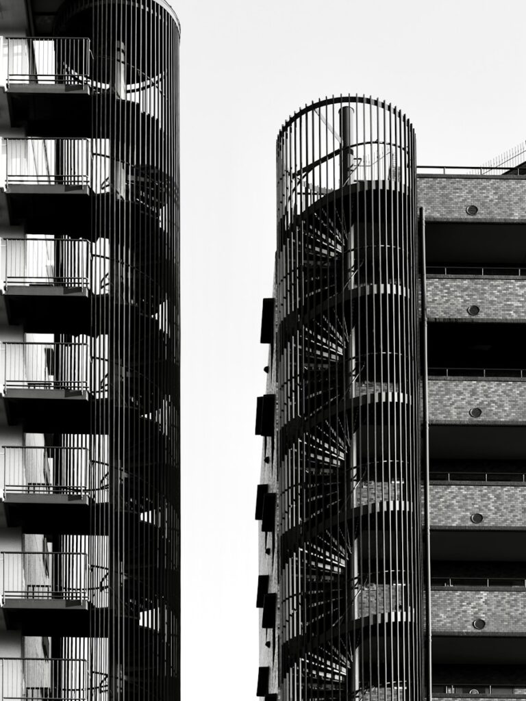 Two modern buildings with spiral staircases against sky